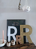 Decorative wooden letters, picture with letter and candle on rustic wooden console