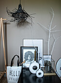 Black table with decorative objects, white branch and black lamp