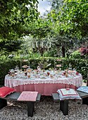 Tea table in the garden with richly laid table and chandelier