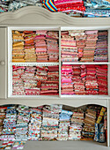 Fabrics sorted by color in a cupboard