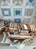 Patchwork blanket, fabrics and spools of thread in baskets