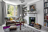 Living room with fireplace, grey sofa and bay window