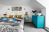 Bedroom with baroque white bed and turquoise-colored furniture