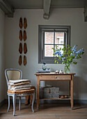 Rustic console table with fresh flowers and antique decorative elements in the hallway