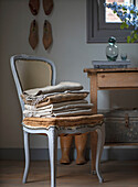 Antique chair with folded linen fabrics next to rustic wooden table