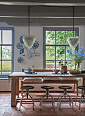 Dining area with rustic wooden table, stools and blue and white wall plates