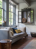 Grey living room with large windows and rustic wall shelf