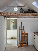 Studio with easel, painting and rustic roof beam