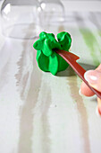 Forming green modeling clay with a plastic tool