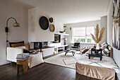 Living room with fireplace, wall decoration and textiles in earthy colours