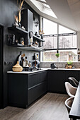 Black kitchen with open shelves and kitchen utensils