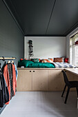 Minimalist sleeping area with integrated storage space and wardrobe rail