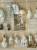 Antique Christmas tree decorations hanging in front of old newspaper
