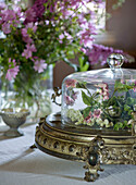 Barocke Servierplatte mit Glaskuppel und floralem Arrangement