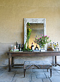Rustic console table with mirror, flowers and house bar