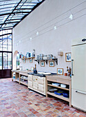 Kitchen unit made of light-colored wood with shelves on the wall above