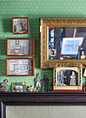Antique toy collection in front of a green wall with paintings