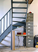 Workshop corner with metal staircase, filing cabinet and table