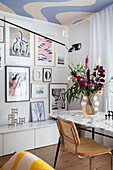 Dining area with marble table top, colorful artwork and bouquet of flowers