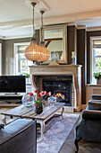 Brightly furnished living room with fireplace and decorative flower vases on the table