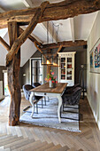 Dining area with rustic wooden table, exposed beams and pendant lights