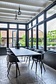 Dining area with large window front and black designer chairs