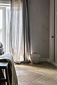 Herringbone parquet flooring and transparent curtains in a modern room