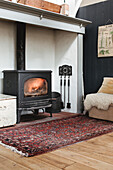 Cosy reading corner with wood-burning stove and oriental rug