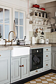 Rural kitchen with ceramic sink, retro cooker and hanging shelves