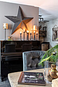 Living room with star as wall decoration and candlestick on piano