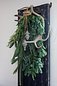 Rustic decoration with fir branches and deer antlers on window shutters