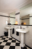 Bathroom with two washbasins and black and white chequered tiles