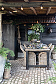 Covered outdoor dining area with rattan chairs, rustic ambience