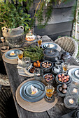 Rustic wooden table outdoors with cake, nuts and candles