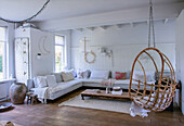 Bright living room with rattan hanging chair and white sofa