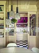 Kitchen with sliding doors, purple accent wall and floor in checkerboard pattern