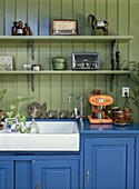 Retro kitchen with blue cupboards, vintage radios and espresso machine