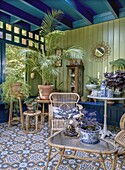 Conservatory with rattan furniture and plants, patterned tiled floor