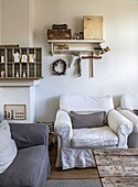 Cozy seating area with white armchairs and rustic wall decoration