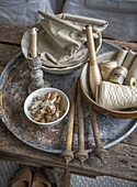 Sewing items on a round metal tray on a rustic wooden table