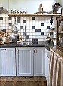 Kitchen with black and white tiles and wooden elements