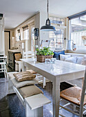 Bright dining area with white wooden table and window seat bench