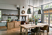 Open country kitchen with rustic wooden table and pendant lights