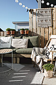 Cosy patio corner with pallet sofa and macramé wall hanging