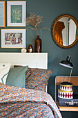 Bedroom with floral bedding, green wall paint and gold-framed pictures