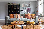 Living room with grey sofa, wooden table and dark display cabinet