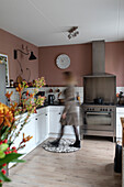 White kitchen with gas hob and pink wall paint