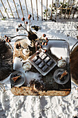 Winter coffee party in the garden on a snow-covered table