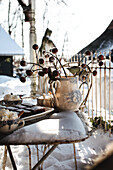 Winter garden table with ceramic vase and biscuits in the snow