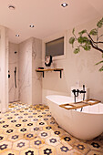Freestanding bathtub in elegant bathroom with patterned tiles